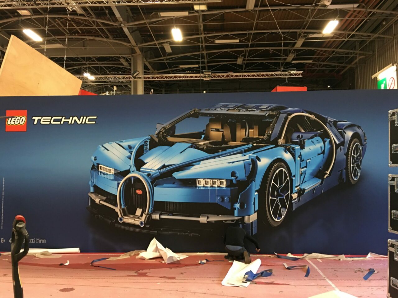 Grand visuel mural représentant une voiture de sport sur un stand d’exposition.