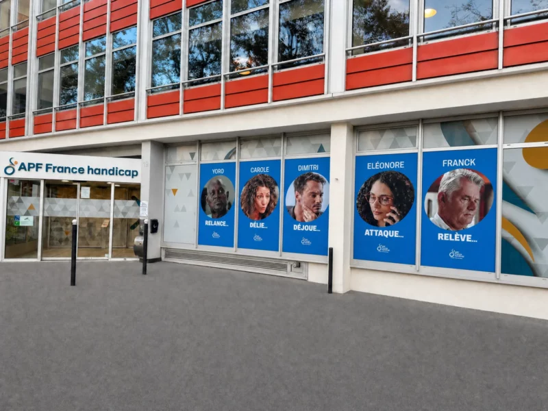 Vue d’ensemble des bâches imprimées avec cinq portraits sur la façade d’APF France handicap à Paris.