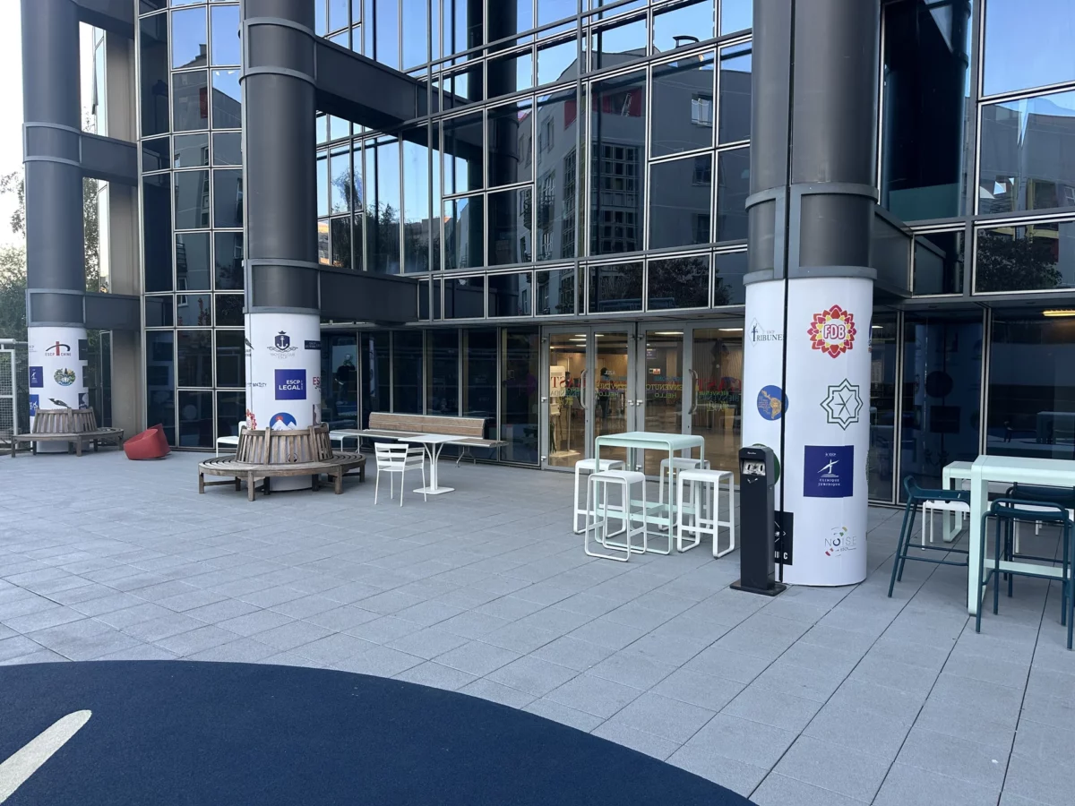 Colonnes de la cour de l’ESCP Porte de Champerret habillées de vinyles blancs imprimés avec les logos des associations.