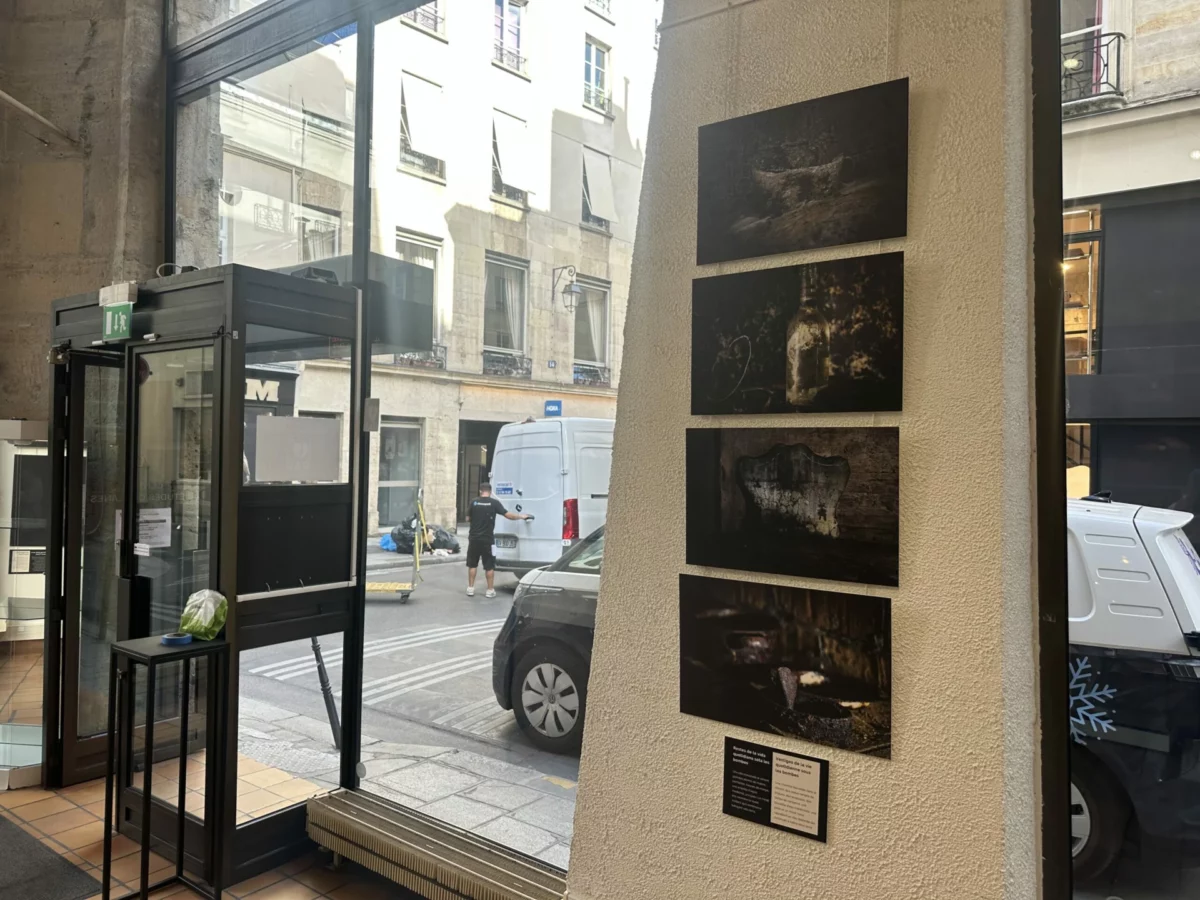 Photographies et légendes installées près de l’entrée vitrée de l’exposition.